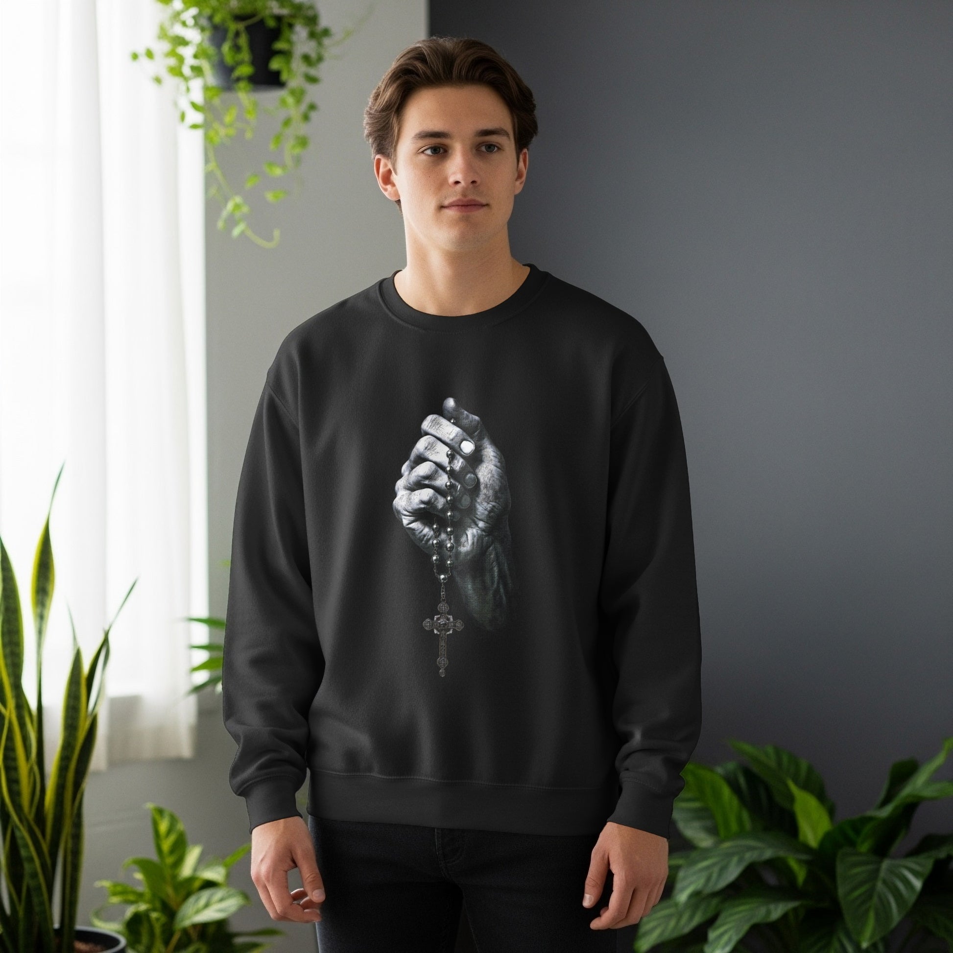 Man wearing black sweatshirt holding rosary beads.