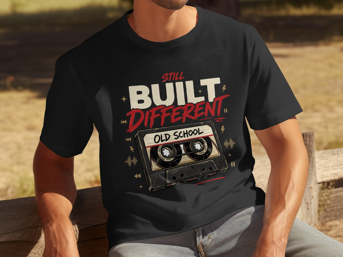 Black t-shirt with "Still Built Different Old School" text and cassette tape graphic.