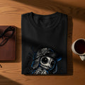 Black t-shirt with a stylized doll graphic wearing a baseball cap.