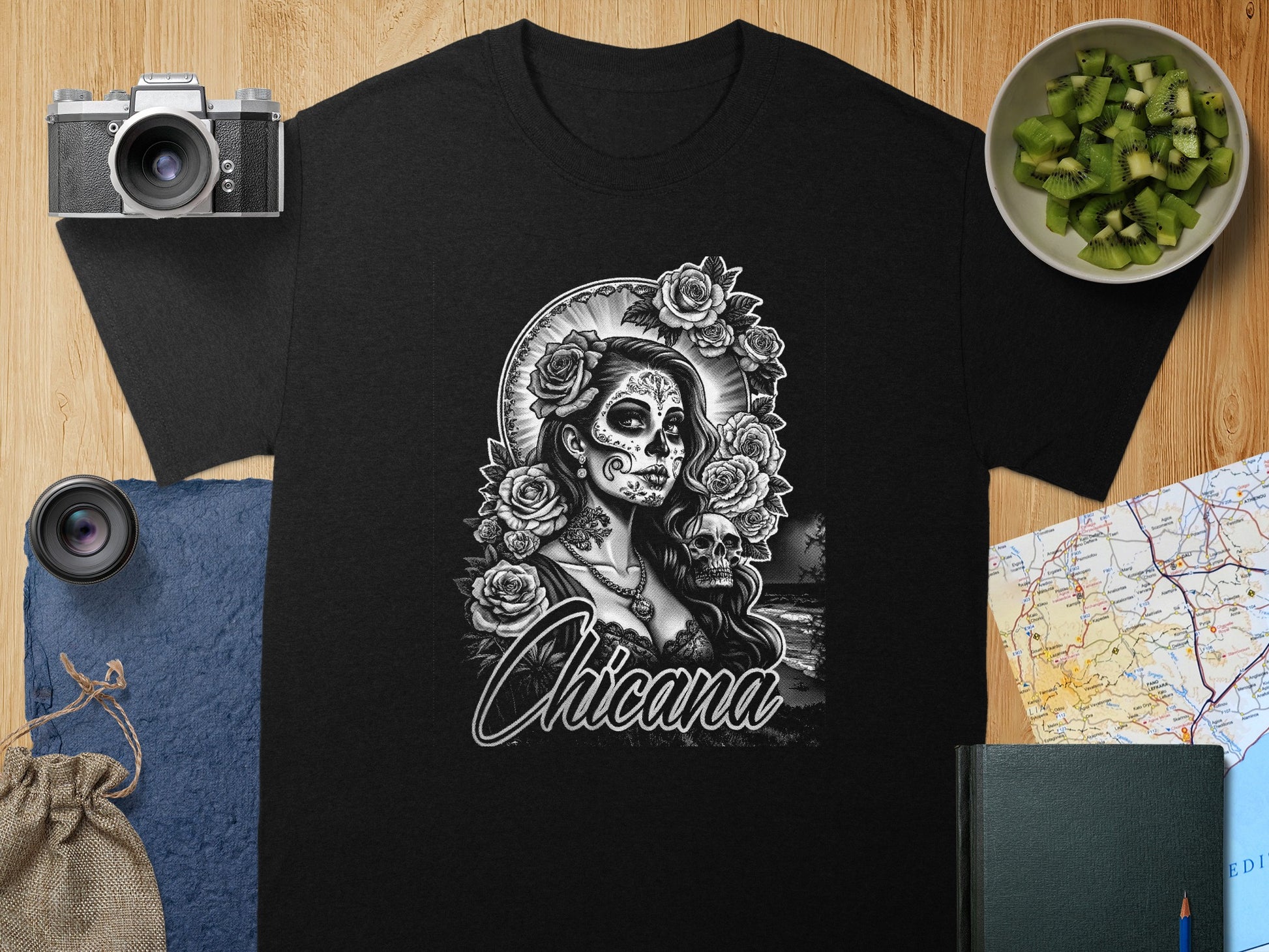 Black t-shirt featuring "Chicana" in ornate lettering with a sugar skull and roses design.