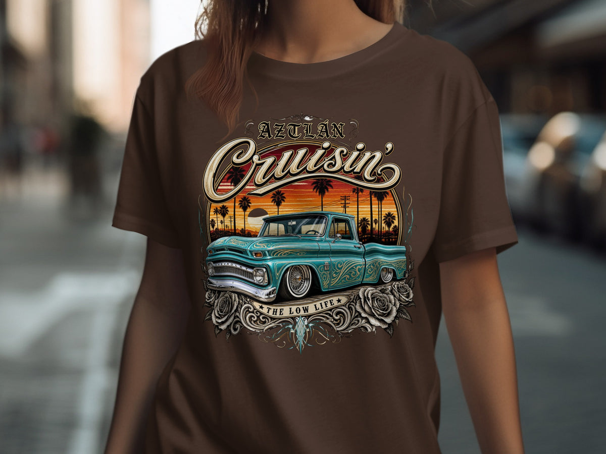 Brown t-shirt with "Aztlan Cruisin'" and a teal lowrider truck design.