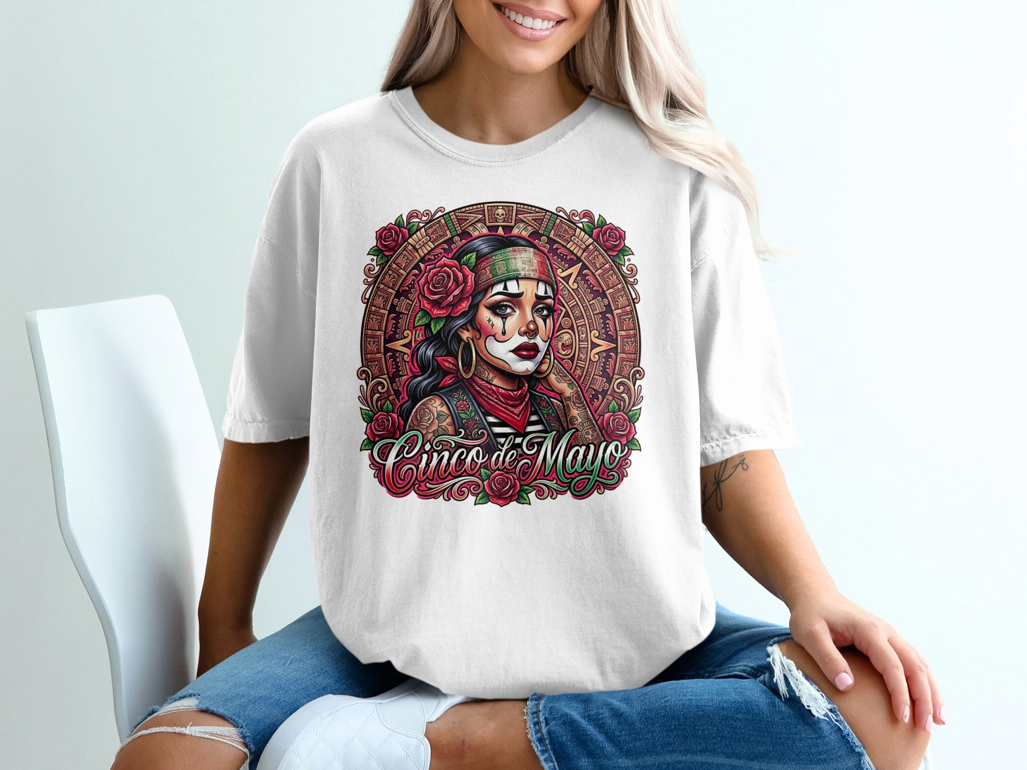 Woman in white t-shirt featuring a Dia de los Muertos skull graphic with roses.