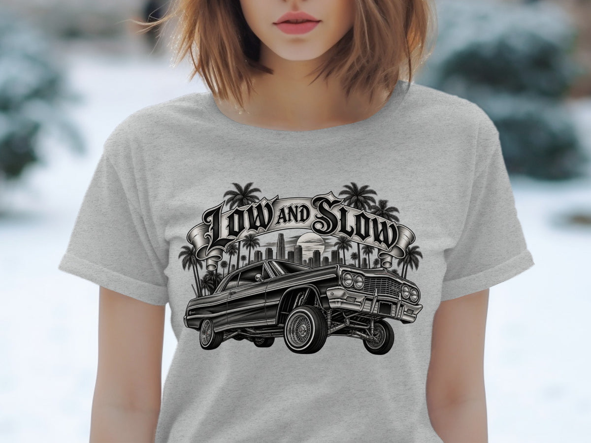 Lowrider car with "Low and Slow" text, palm trees, and cityscape design.