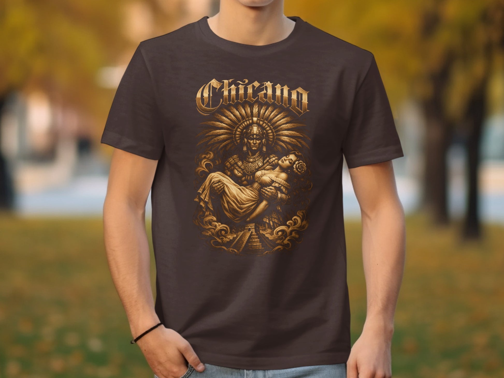 Brown t-shirt with ornate "Chicano" text and image of a warrior holding a woman.