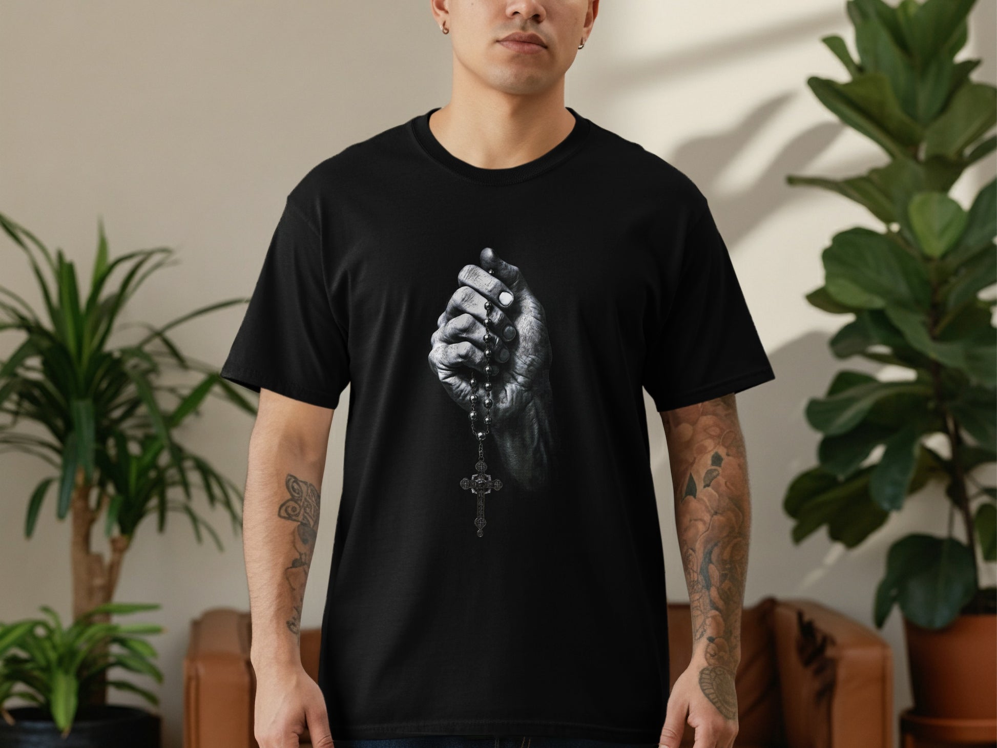 Black t-shirt with graphic of hands holding rosary beads.