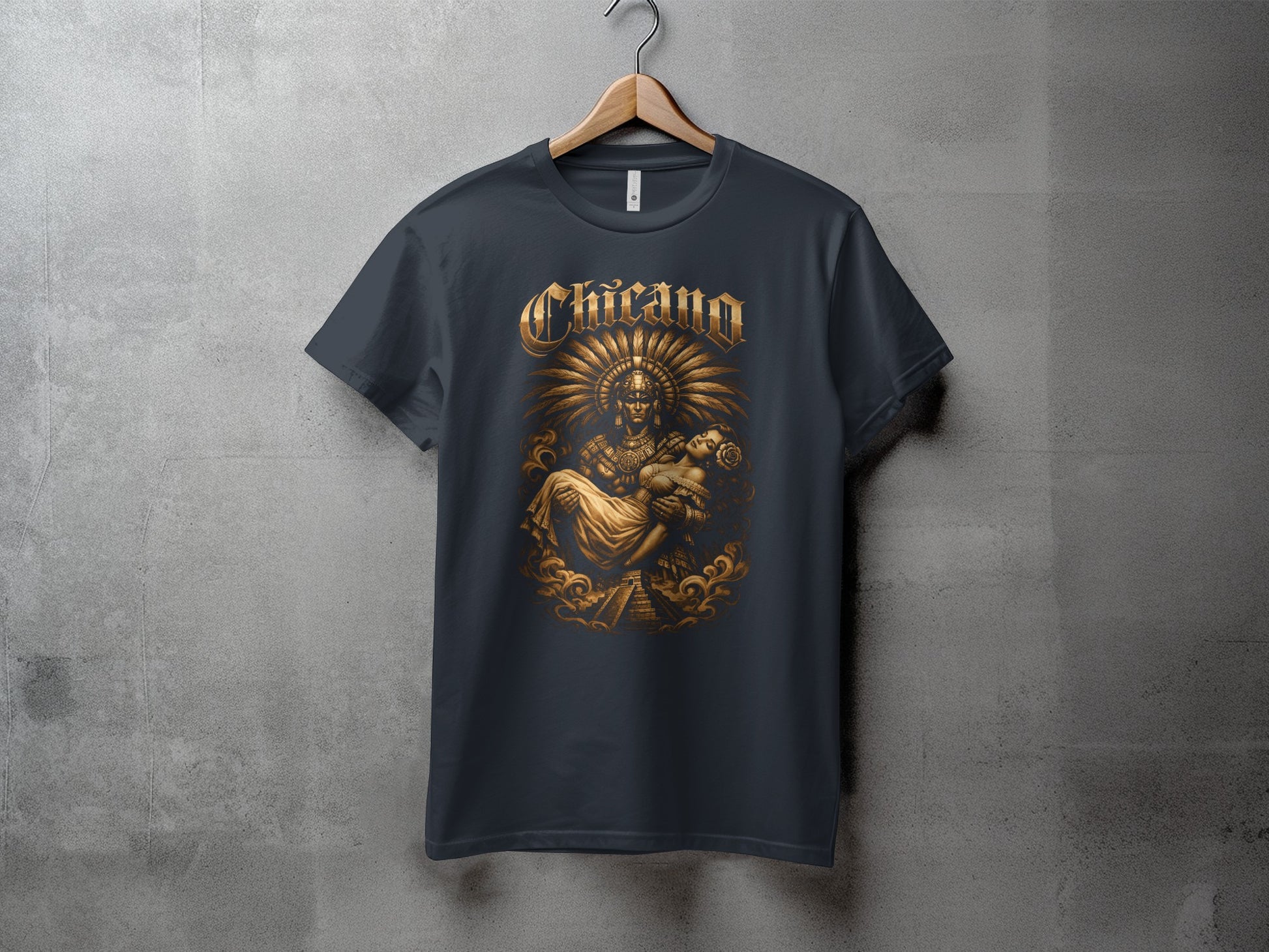 Dark t-shirt with "Chicano" text and golden Aztec imagery of a warrior holding a child.
