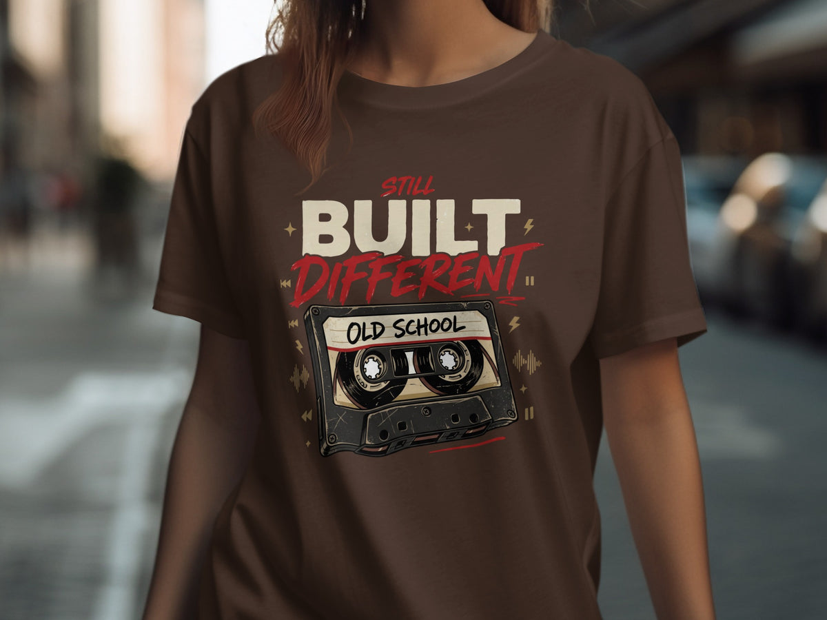 Brown t-shirt with "Still Built Different Old School" text and cassette tape graphic.