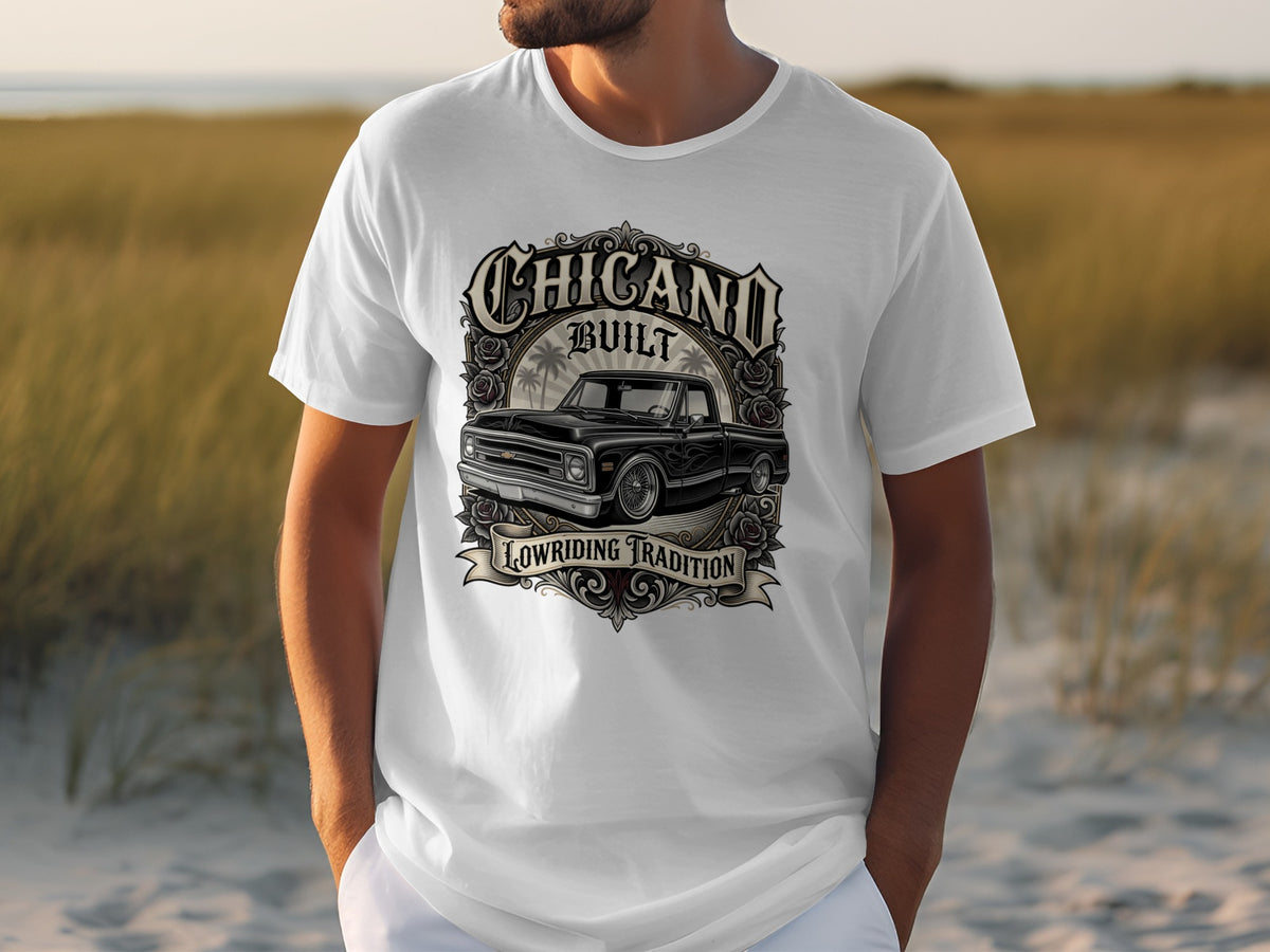 White t-shirt with "Chicano Built Lowriding Tradition" graphic featuring a classic black pickup truck.