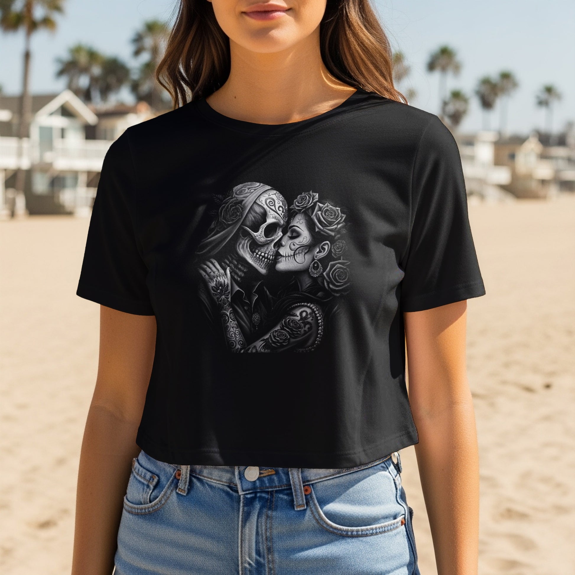 Black t-shirt with Day of the Dead sugar skull couple graphic on beach.