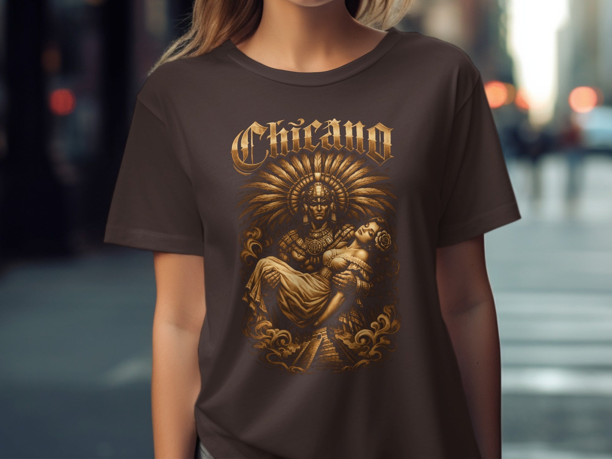 Brown t-shirt with gold Chicano-themed Aztec warrior graphic carrying a woman.