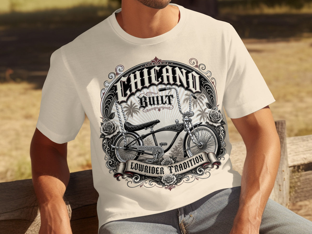 Cream t-shirt with "Chicano Built Lowrider Tradition" graphic featuring a bicycle, roses, and palm trees.