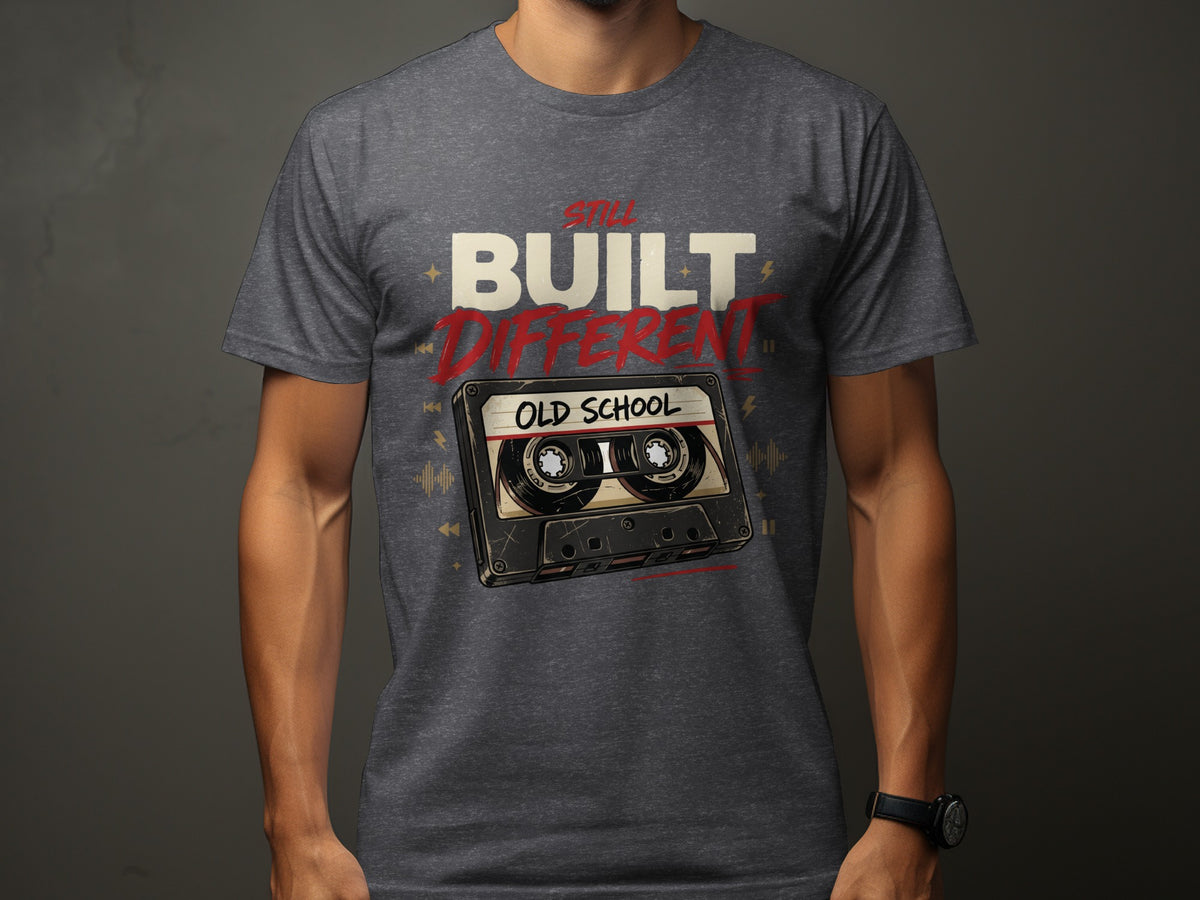 T-shirt with "Still Built Different" text and old school cassette tape graphic.