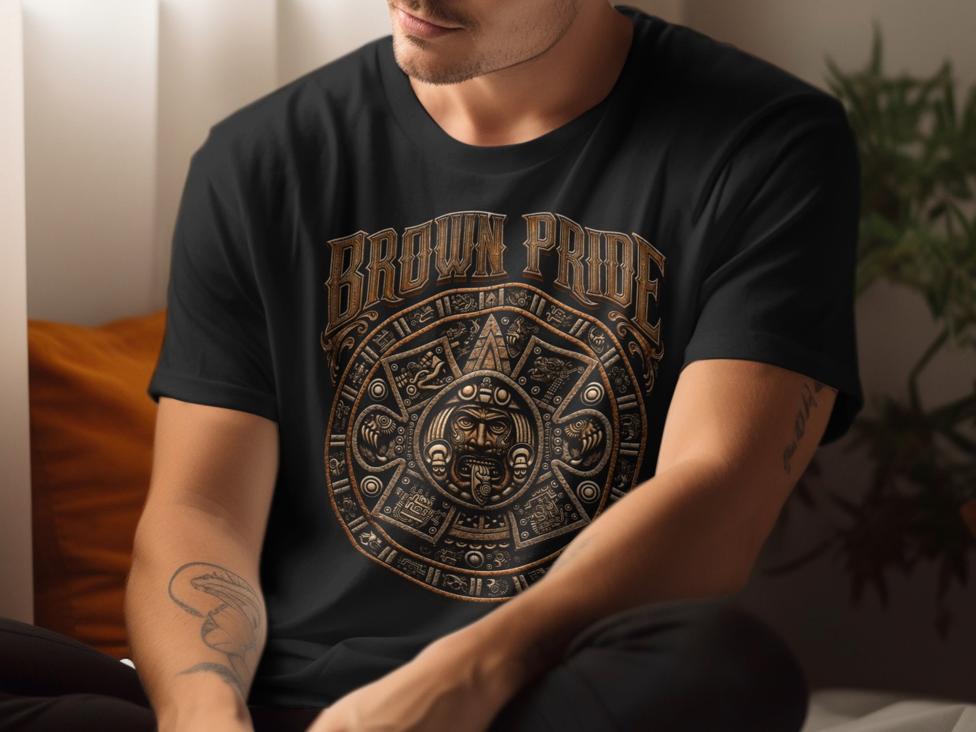 Black t-shirt with "Brown Pride" text and a gold Aztec calendar design.