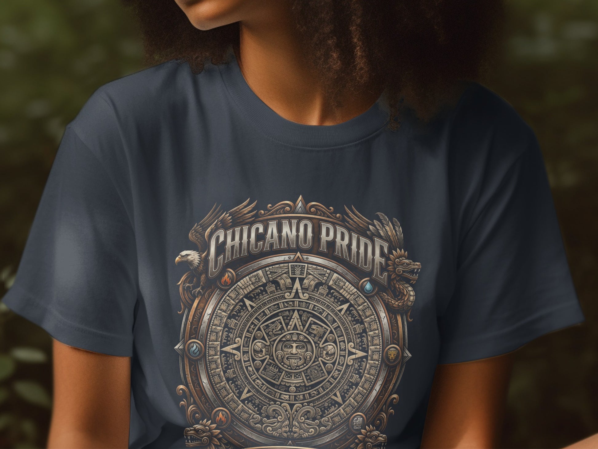 Dark t-shirt with circular Chicano Pride emblem featuring eagle and serpent.