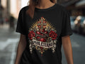 Black t-shirt with thorny heart, roses, cross, flames, and text 