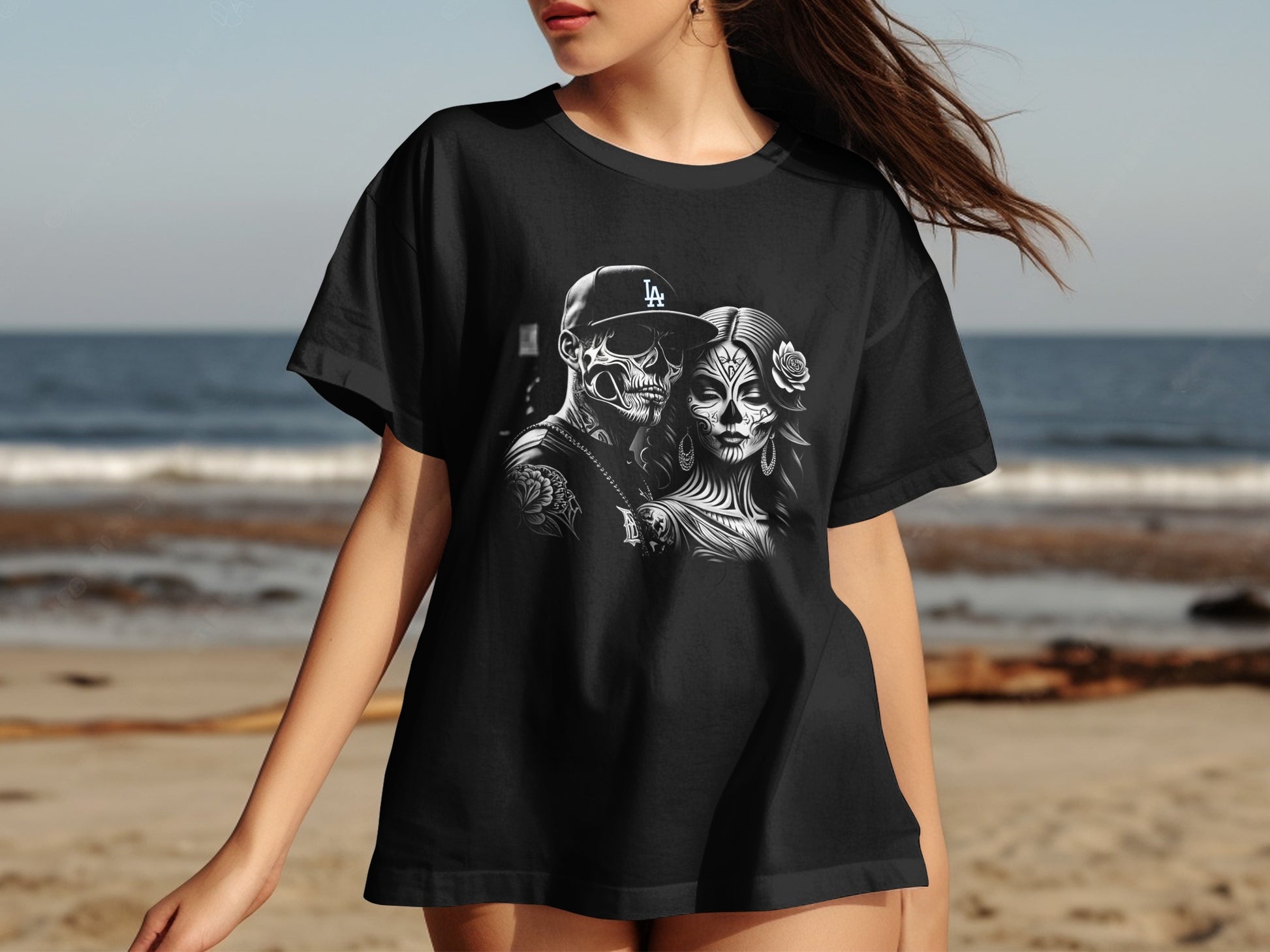 Black t-shirt with sugar skull couple design on beach background.