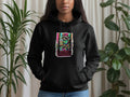 Black hoodie with a cartoon raccoon holding a coffee cup and 