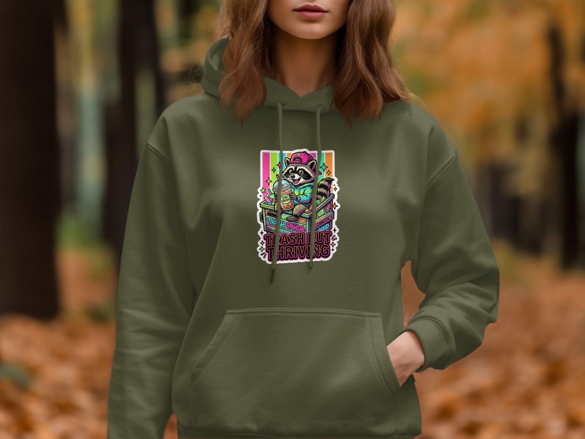 Green hoodie with colorful "Trash Out Thriving" graphic featuring a raccoon.