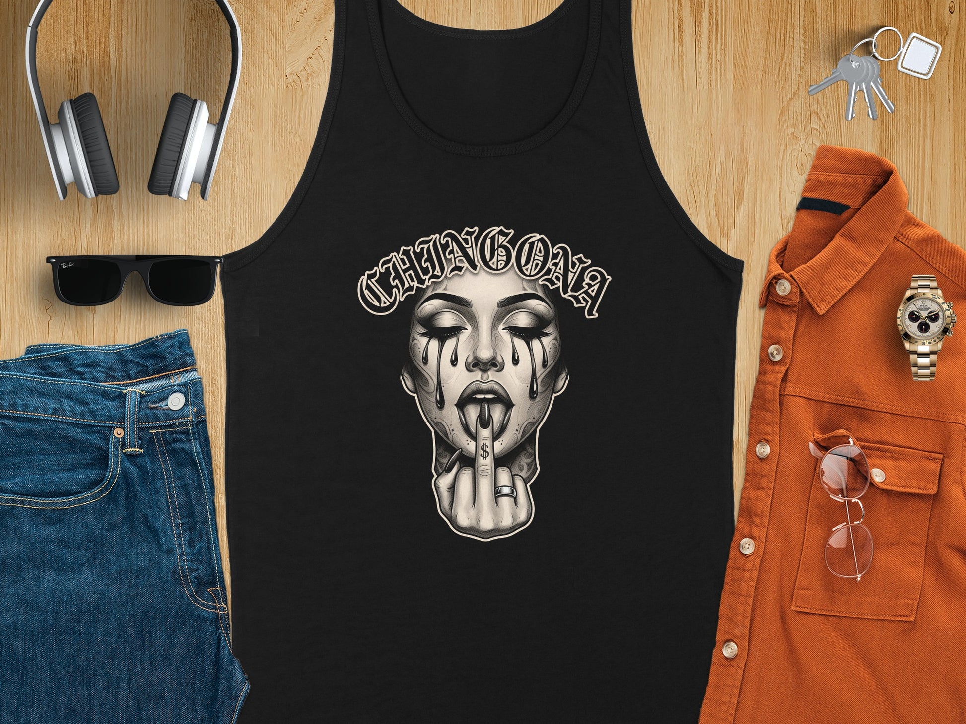 Black tank top with "CHINGONA" text and crying skull graphic, surrounded by jeans, shirt, sunglasses, and watch.