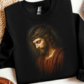 Jesus wearing a crown of thorns, looking down, on a black sweatshirt.