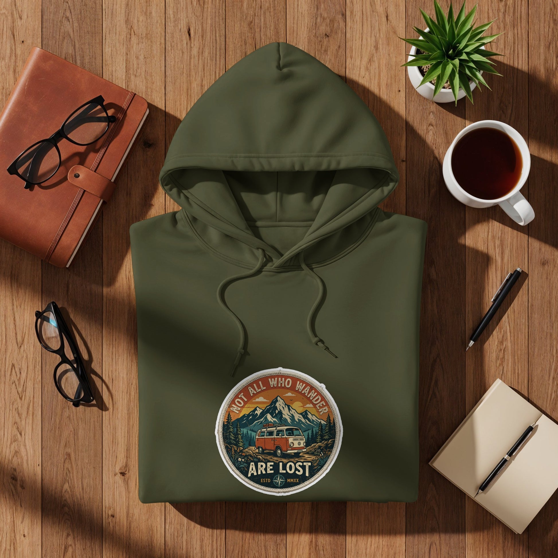 Olive green hoodie with circular "Not All Who Wander Are Lost" patch featuring a van.