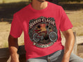 Red t-shirt featuring a circular graphic of a vintage bicycle, palm trees, and roses. Text reads 