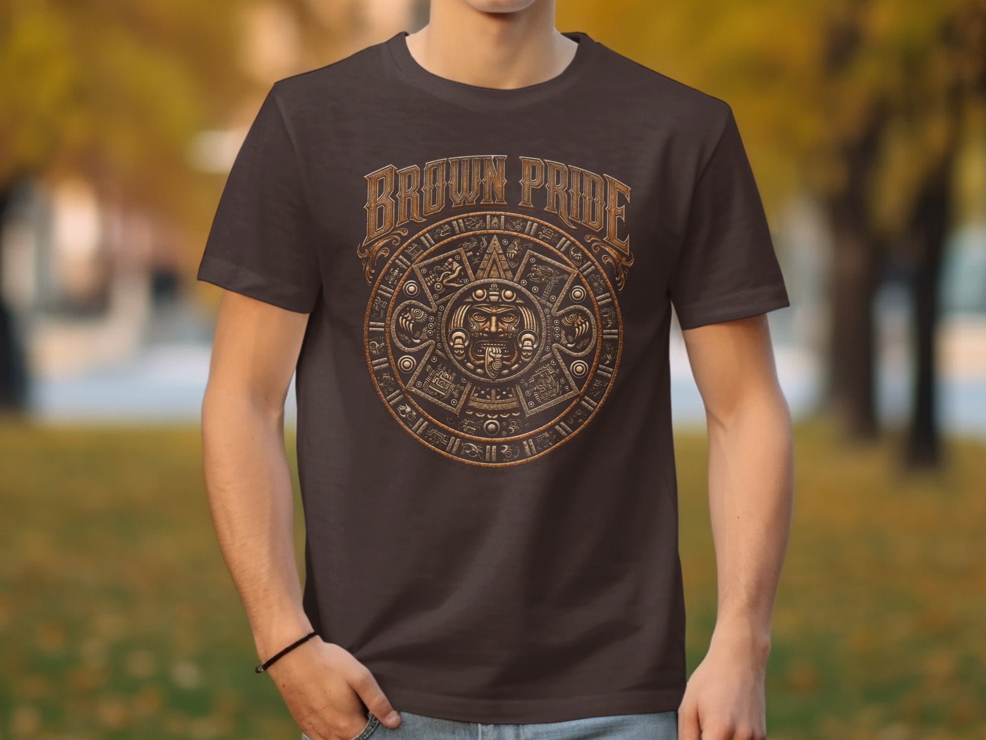 Brown t-shirt with a circular Aztec-inspired design featuring a face and text.