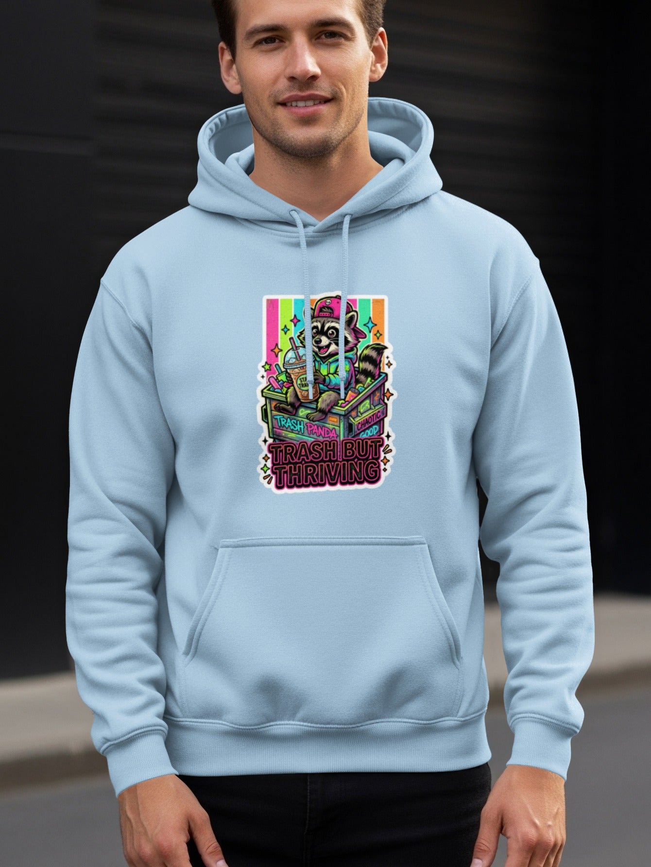Hoodie with cartoon raccoon wearing a hat, holding a drink, "Trash Panda Thriving" text.