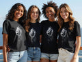 Four young women wear t-shirts with a praying hands and rosary bead graphic.