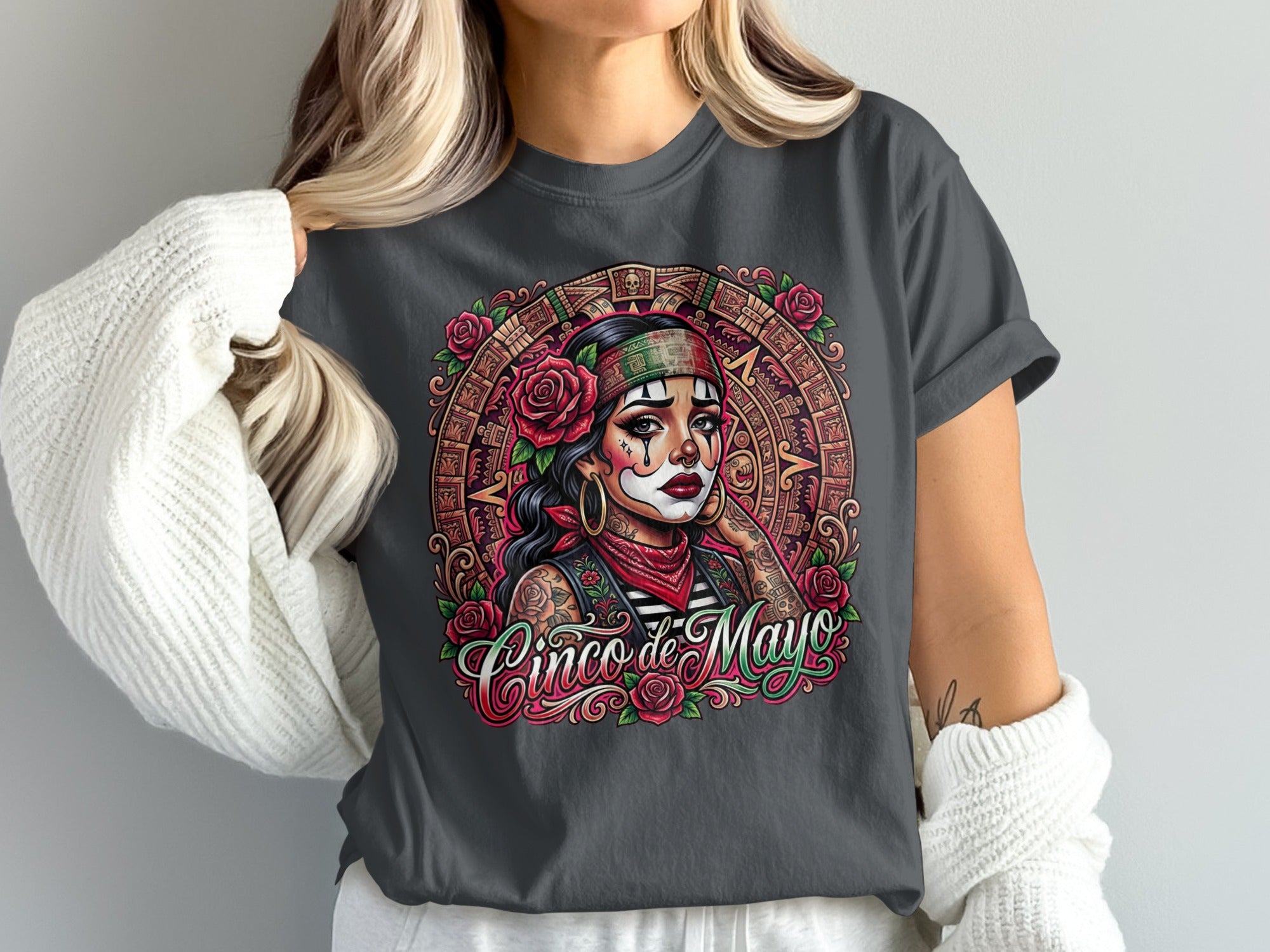Woman wearing a t-shirt with a colorful Aztec-inspired "Cinco de Mayo" graphic.