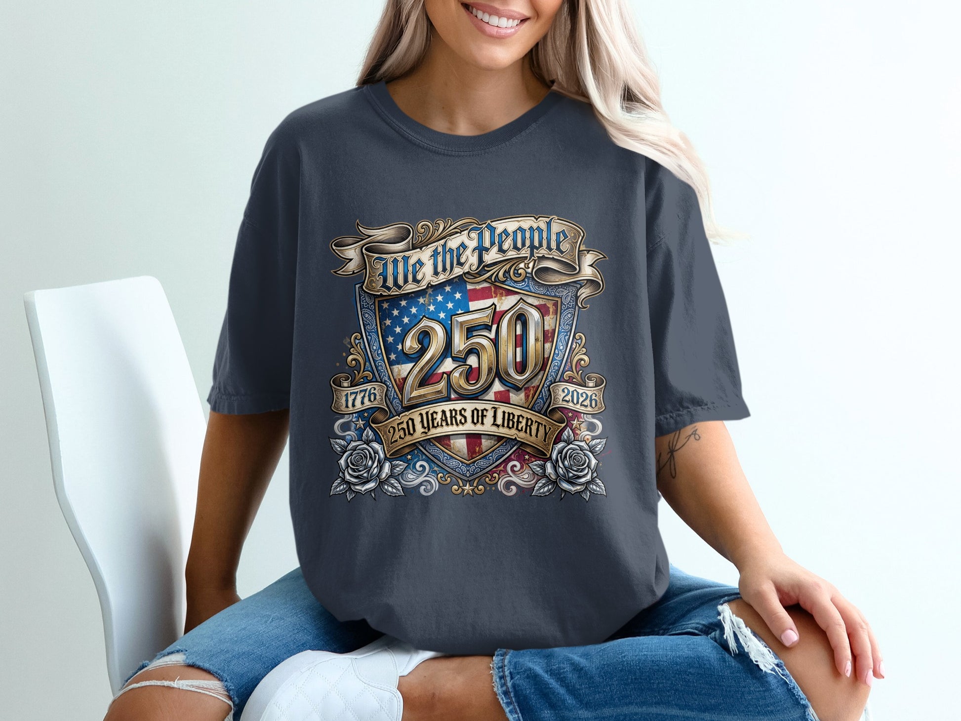 Dark grey t-shirt with "We the People 250 Years of Liberty 1776 2026" text and US flag shield.