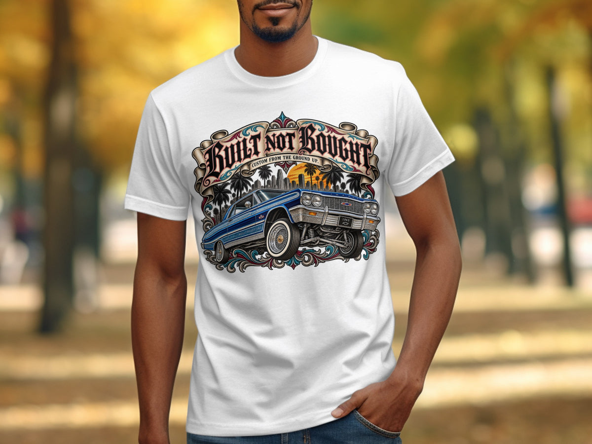 White t-shirt with "Built Not Bought" graphic featuring a blue lowrider car.