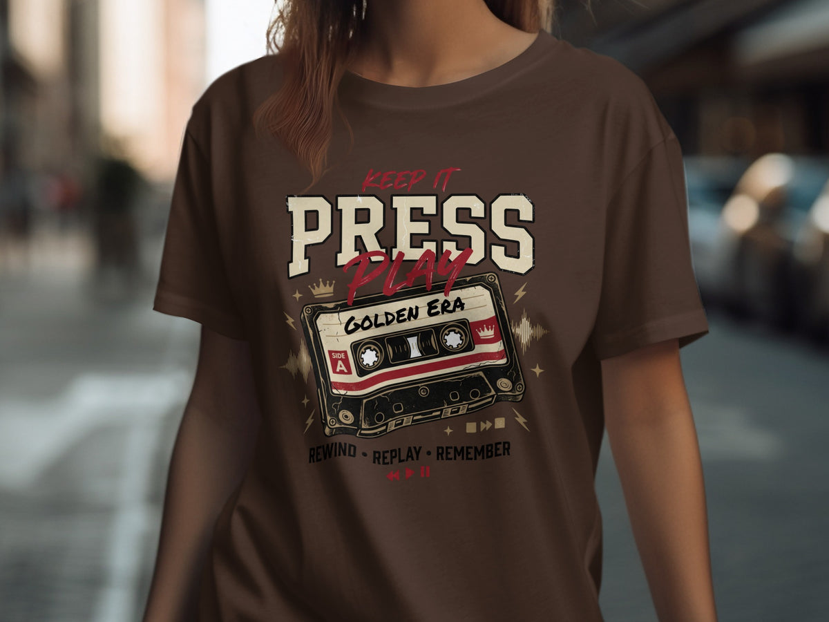 Brown t-shirt with "Keep It Press Play Golden Era" and a cassette tape graphic.