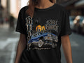 Black t-shirt with blue lowrider, city skyline, palm trees, and 