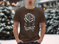 Brown t-shirt with a black and white rose and banner saying 