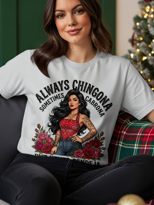 Woman wearing a white t-shirt with "Always Chingona Sometimes Cabrona" text and floral design.