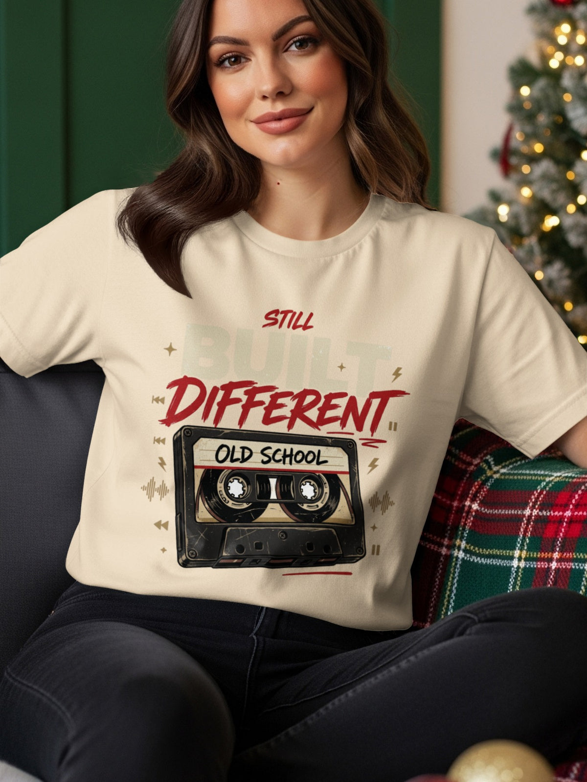 Cream t-shirt with red text "STILL BUILT DIFFERENT OLD SCHOOL" and a cassette tape graphic.