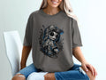 Dark grey t-shirt with a stylized doll wearing a baseball cap and backpack.