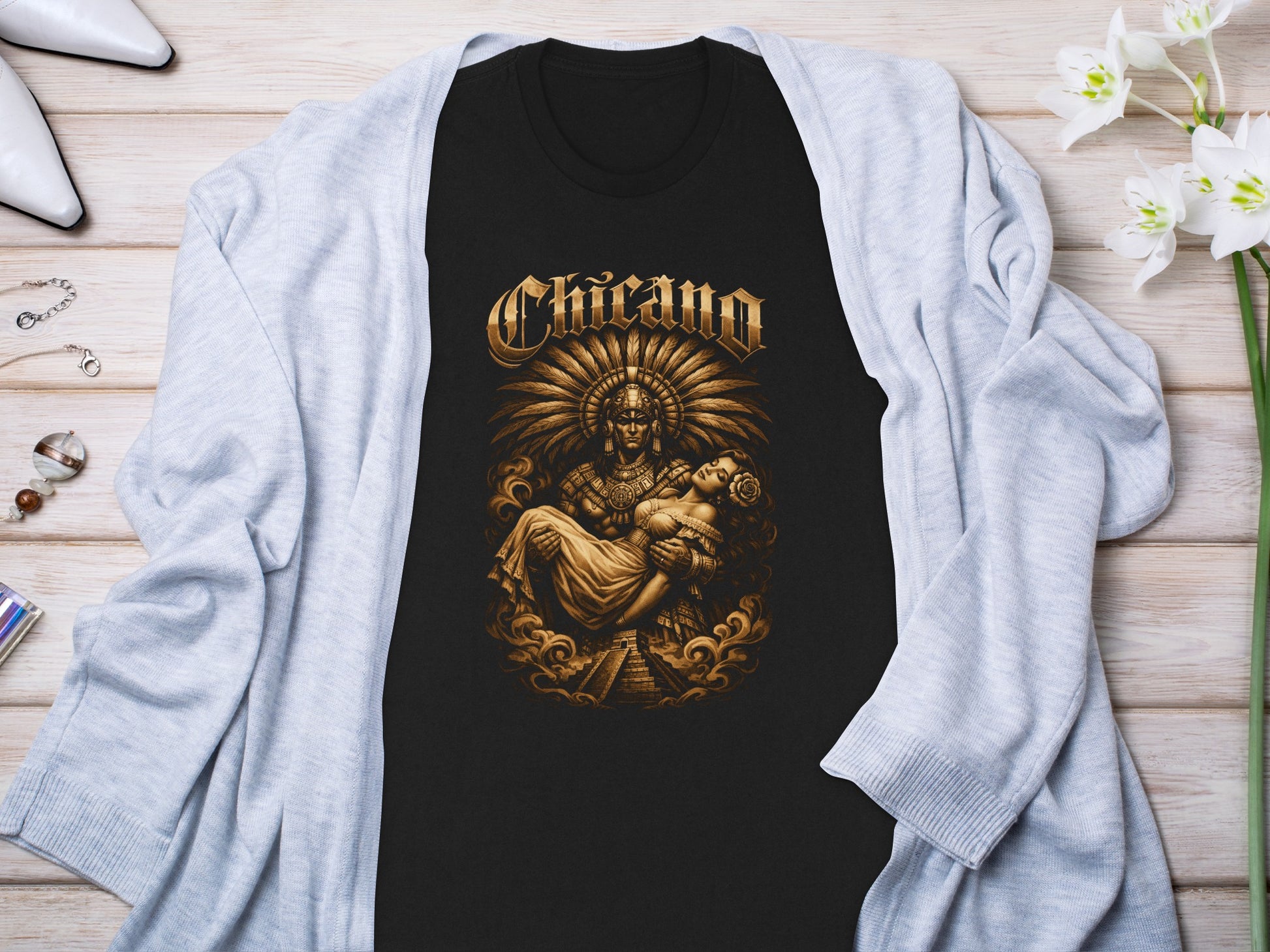 Black t-shirt with "Chicano" text and indigenous deity holding a woman.