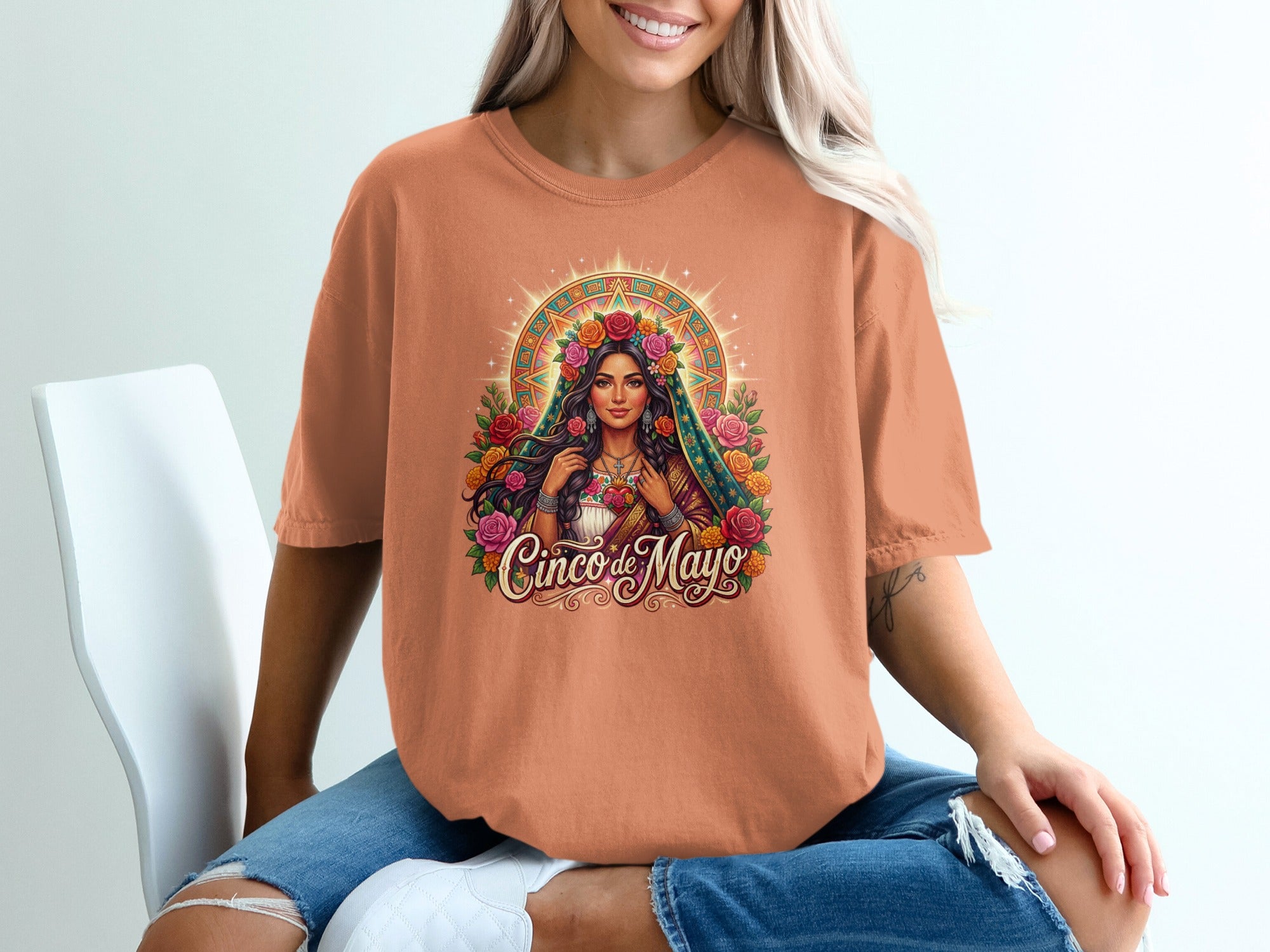 Woman wearing orange t-shirt with floral halo woman graphic.