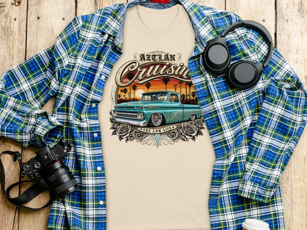 Beige t-shirt with a graphic of a teal 1960s Chevrolet pickup truck and "Aztlan Cruisin" text.