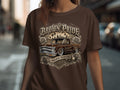 Brown Pride lowrider truck with roses and city skyline design on a brown t-shirt.