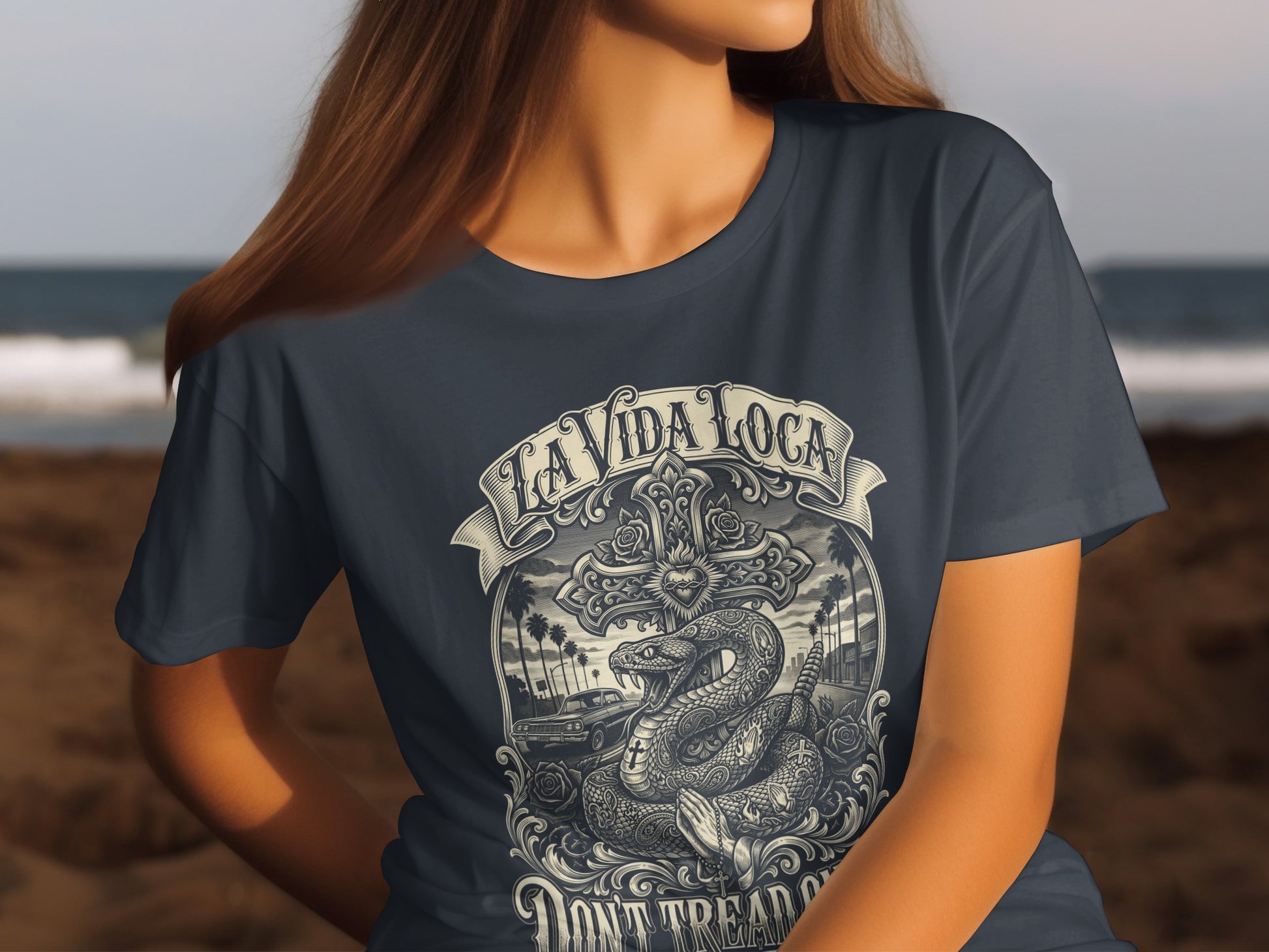 Dark t-shirt with La Vida Loca snake and cross graphic, palm trees, and car.