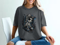 Dark grey t-shirt with graphic of a stylized doll wearing a baseball cap.