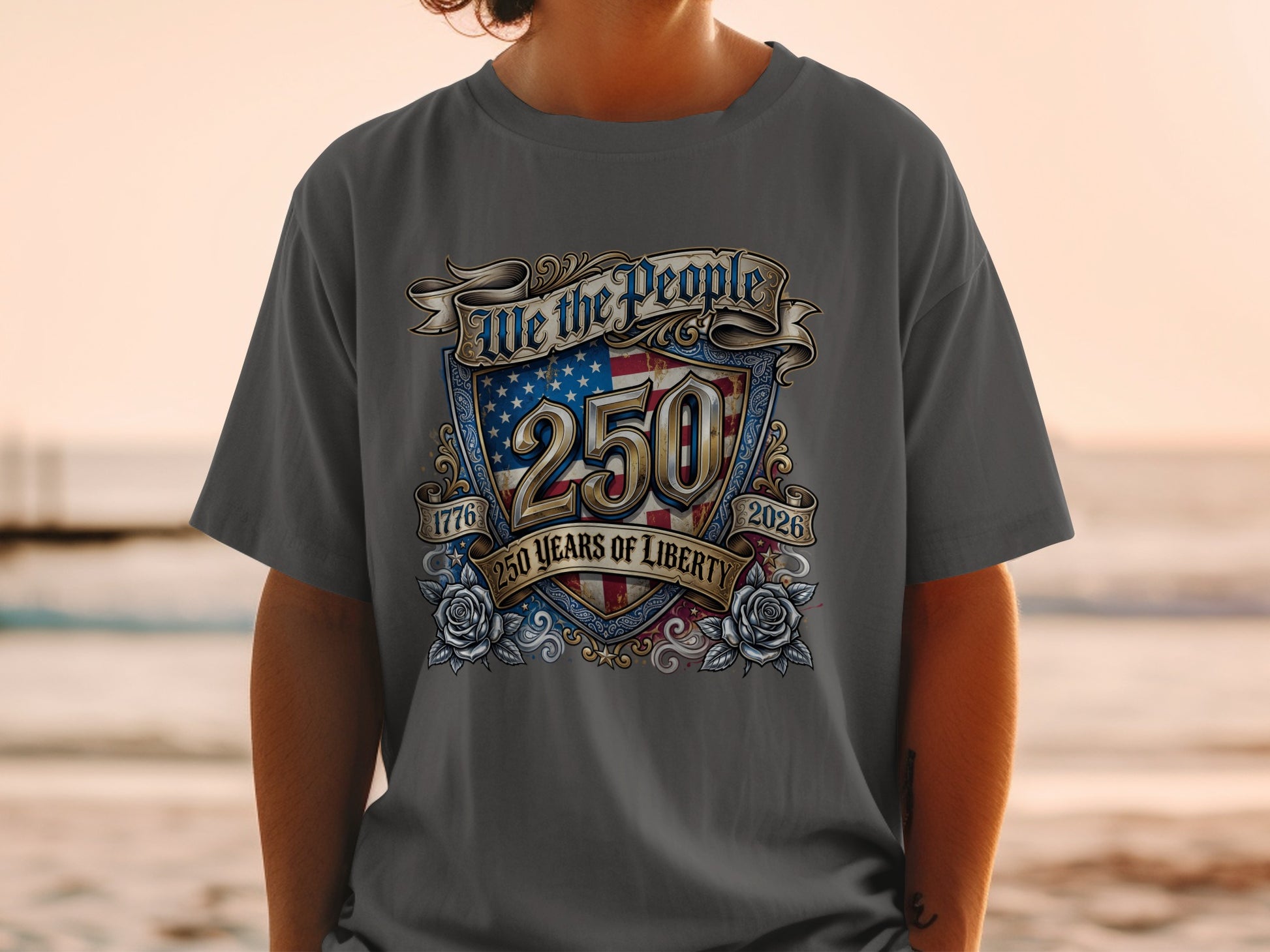 Dark grey t-shirt with "We the People 250 Years of Liberty 1776 2026" and shield graphic.