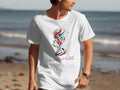 White t-shirt with colorful World Cup 2026 logo on a beach.