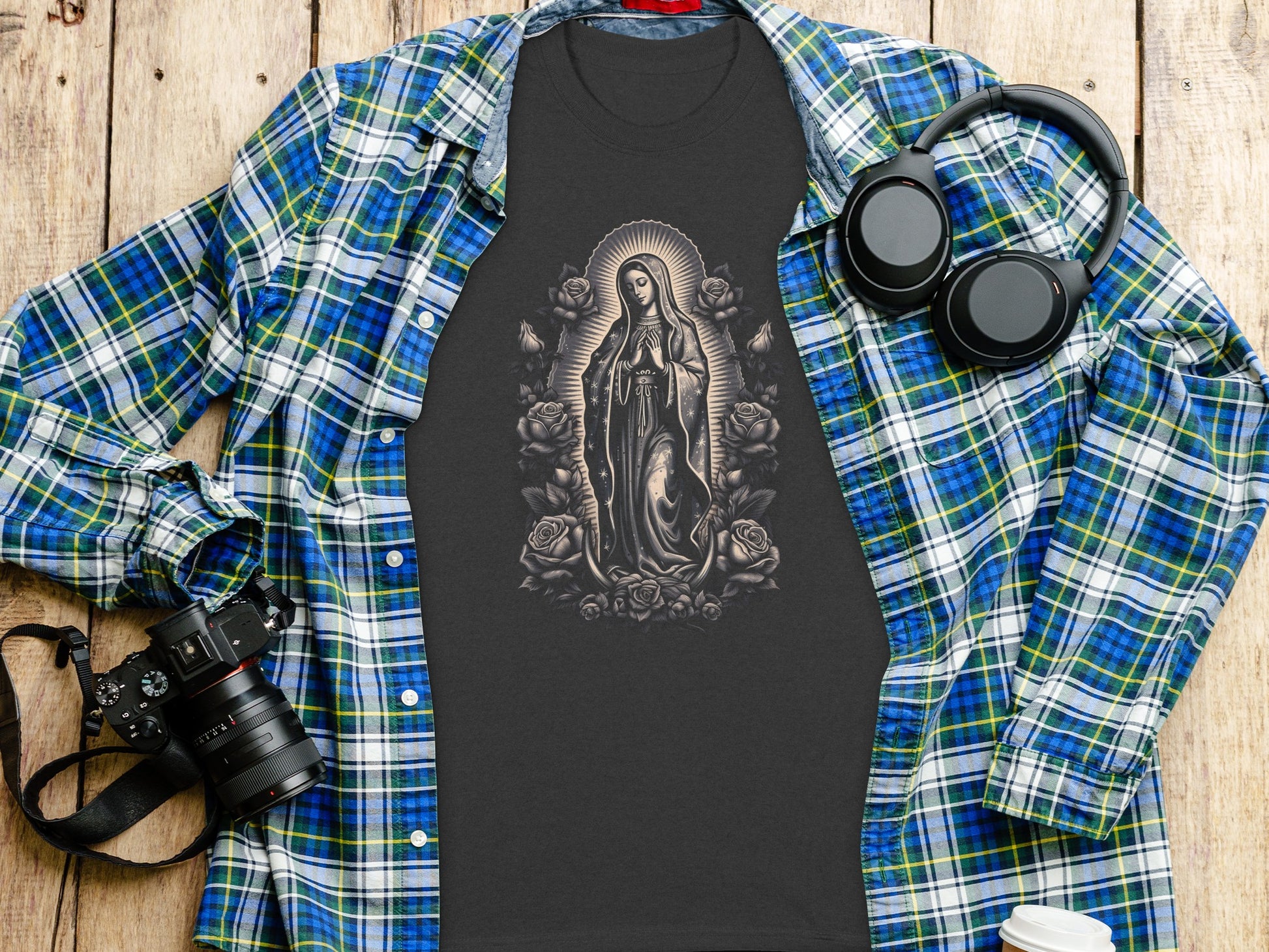 Dark t-shirt with Virgin Mary and roses graphic, layered under plaid shirt.