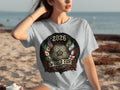 2026 World Cup emblem with flags, soccer ball, and roses on a grey t-shirt.