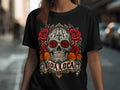 Black t-shirt with sugar skull, roses, marigolds, and banner reading 