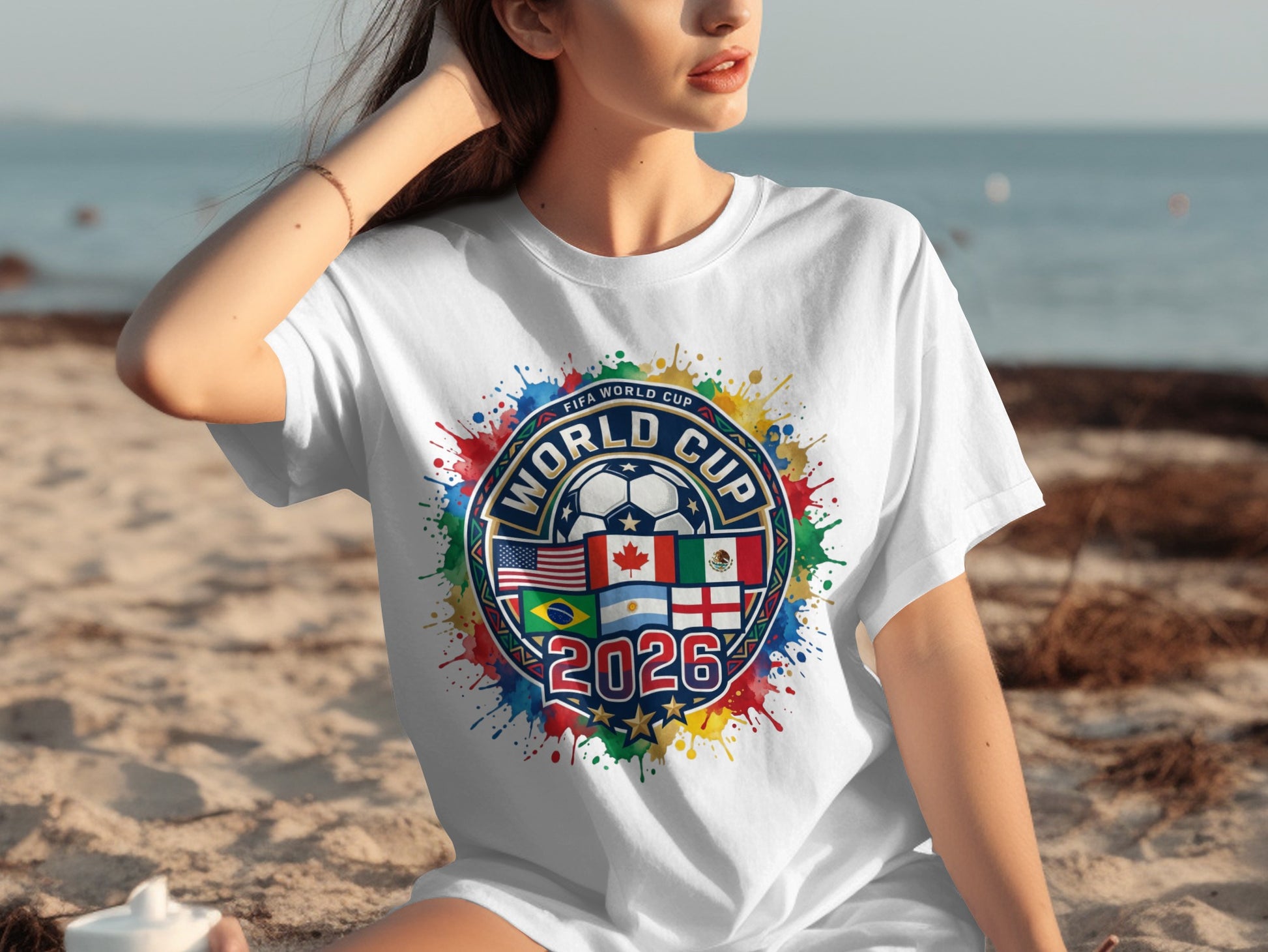 White t-shirt with 2026 FIFA World Cup logo featuring flags and colorful paint splatters.